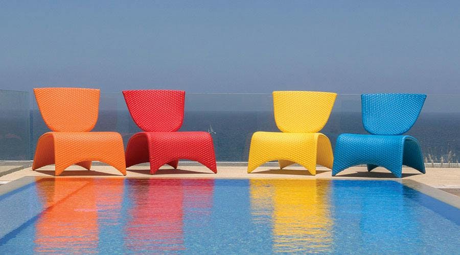 orange, red, yellow and blue zuma chairs poolside 