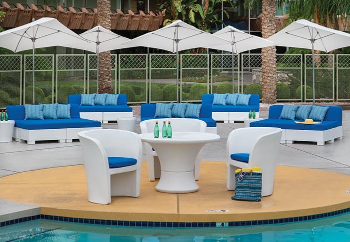 white poolside furnishings with blue cushions