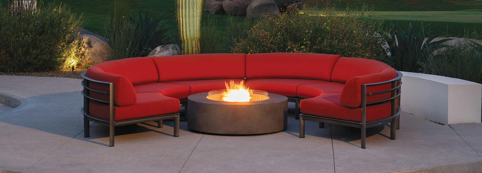 modular sofa with red cushions around a fire table