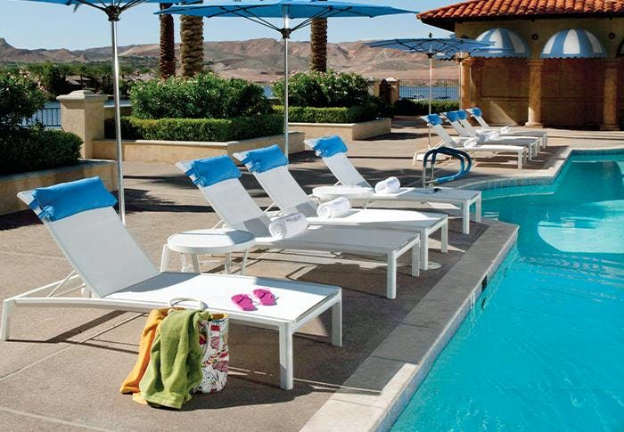 white lounge chairs poolside